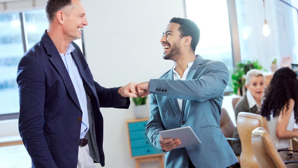 Um candidato sorrindo e apertando a mão de um recrutador, enquanto outros candidatos ao fundo parecem confusos. A imagem transmite a ideia de que o candidato em destaque tem um diferencial.